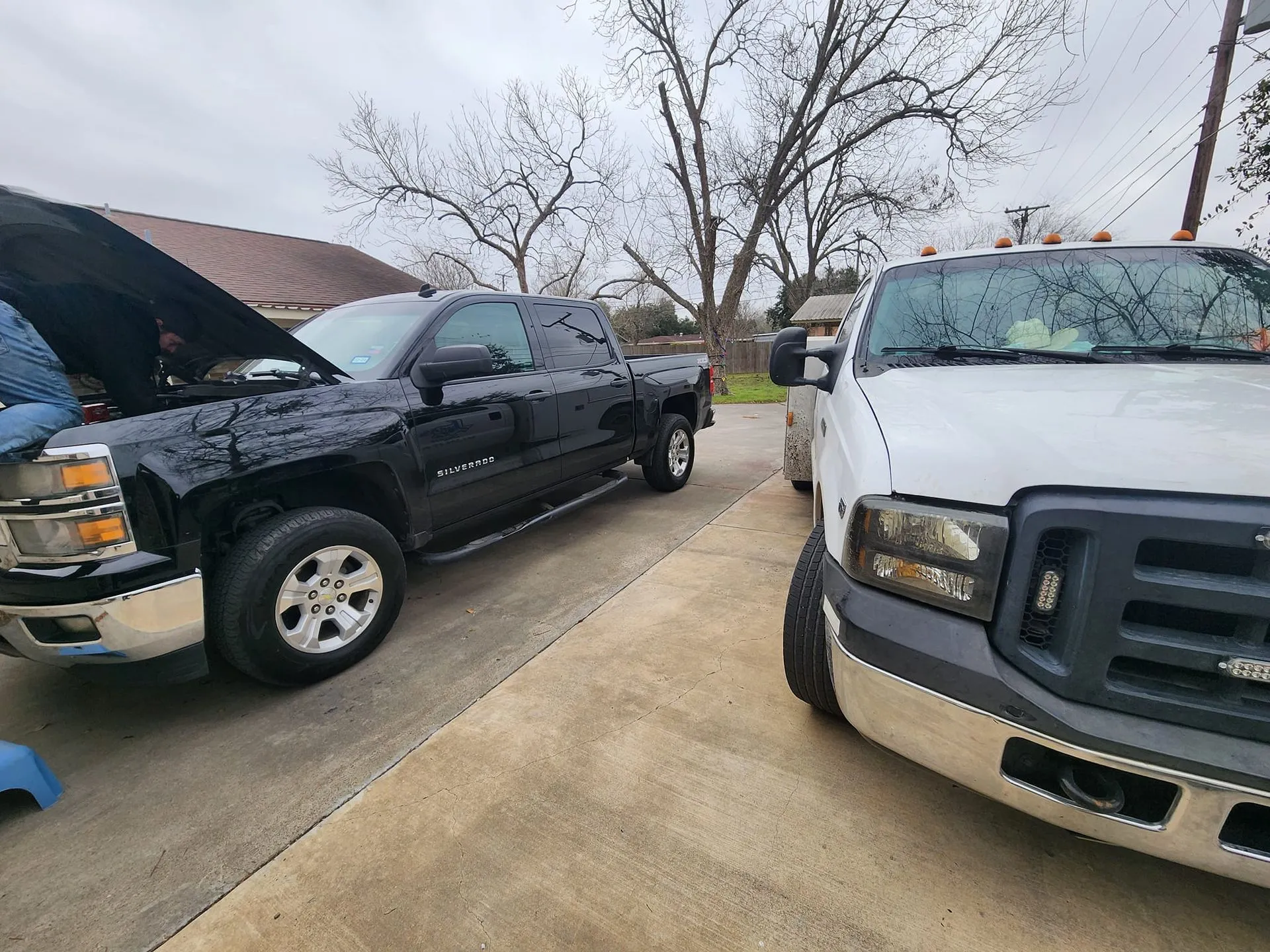 Two Lynn's Road Service pickup trucks parked outside on a cloudy day.