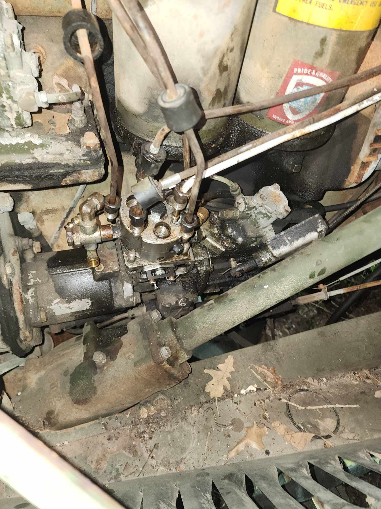 Close-up of a greasy black engine with wires and tubes.