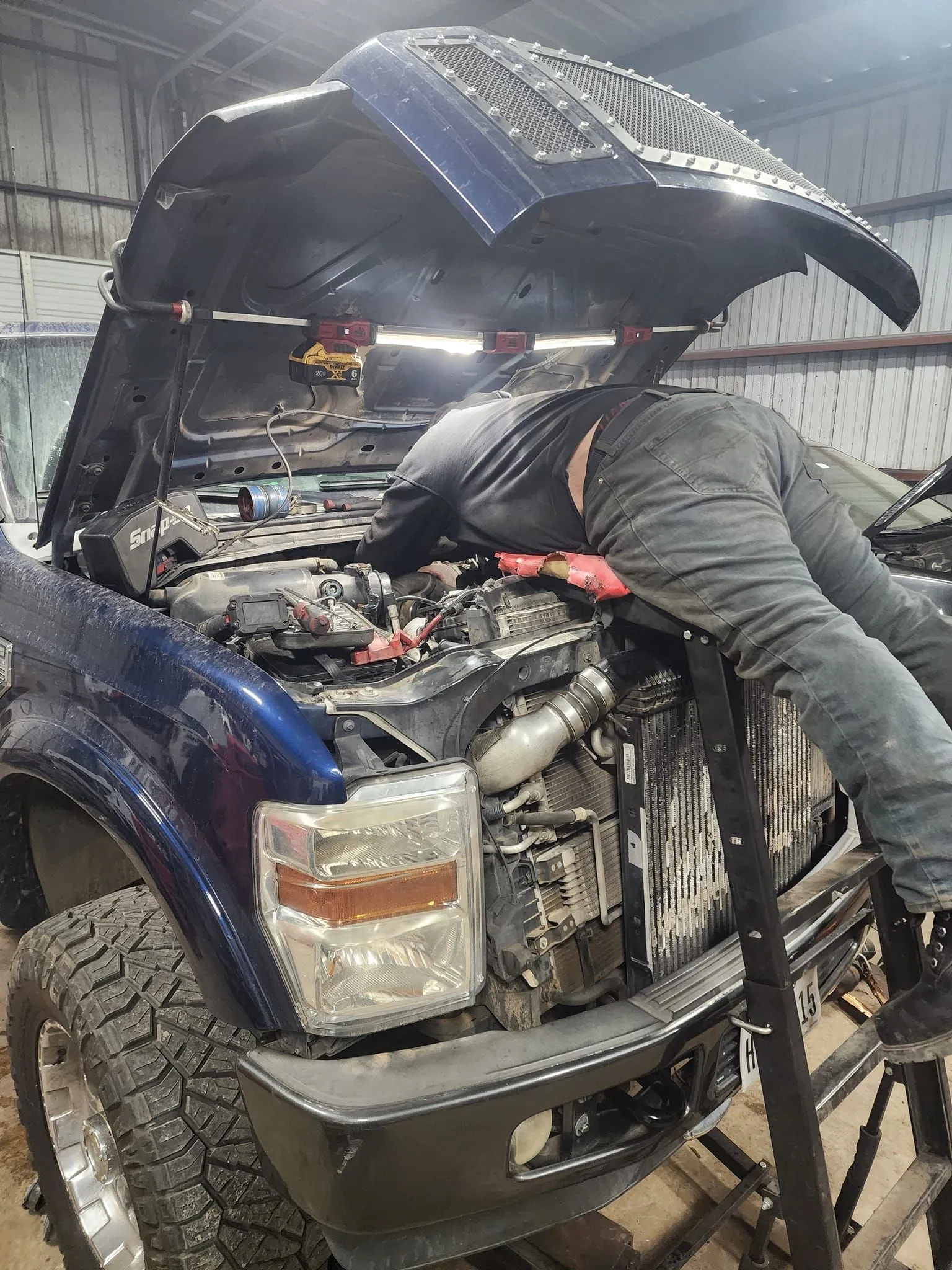 Person working on a blue truck engine